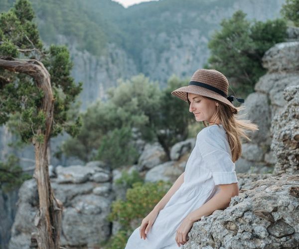 Person meditating peacefully outdoors with soft natural light.